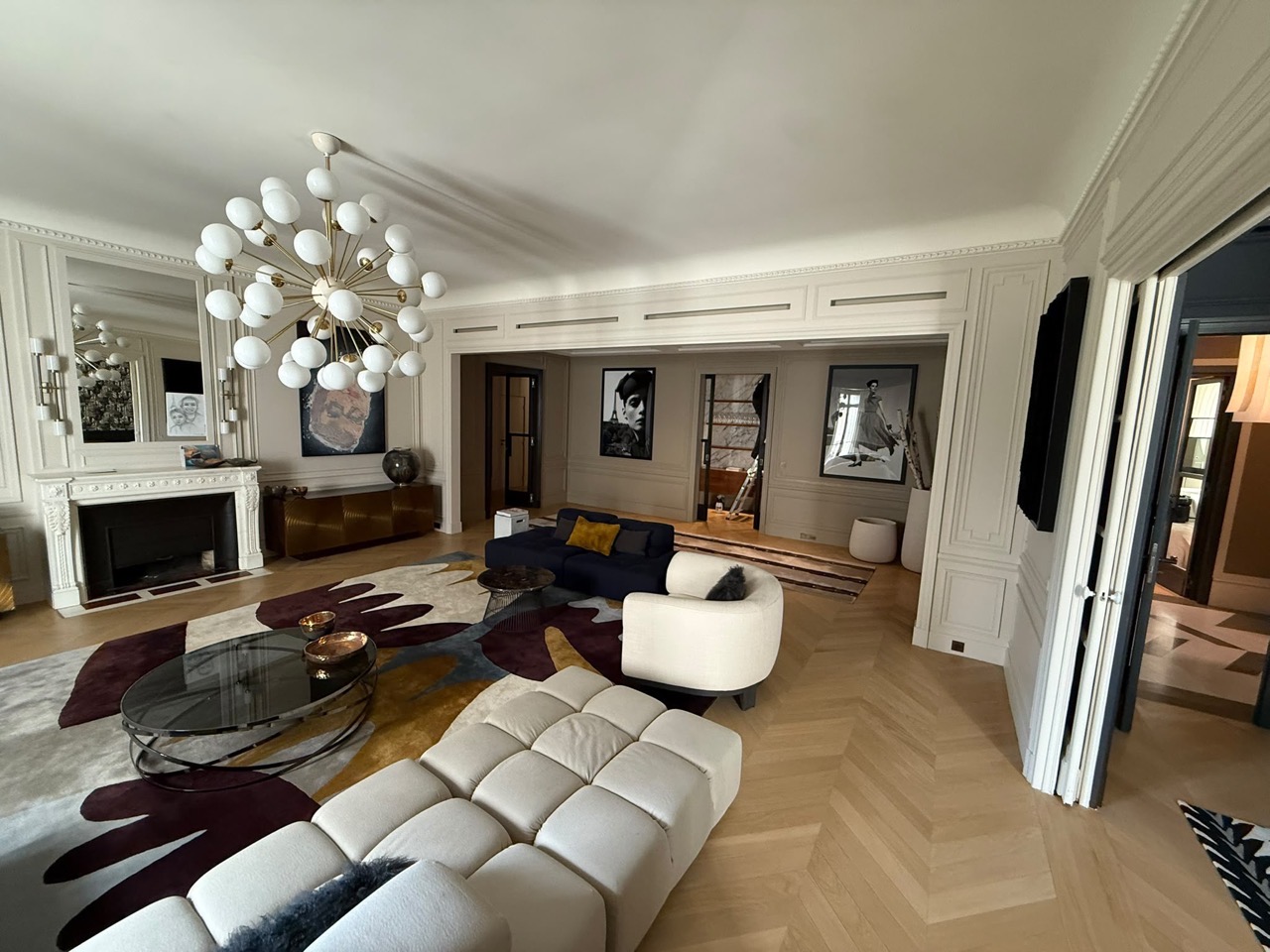 Séjour d'un appartement haussmannien : grilles de diffusion linéaires intégrées au caisson du plafond, au-dessus des ouvertures.