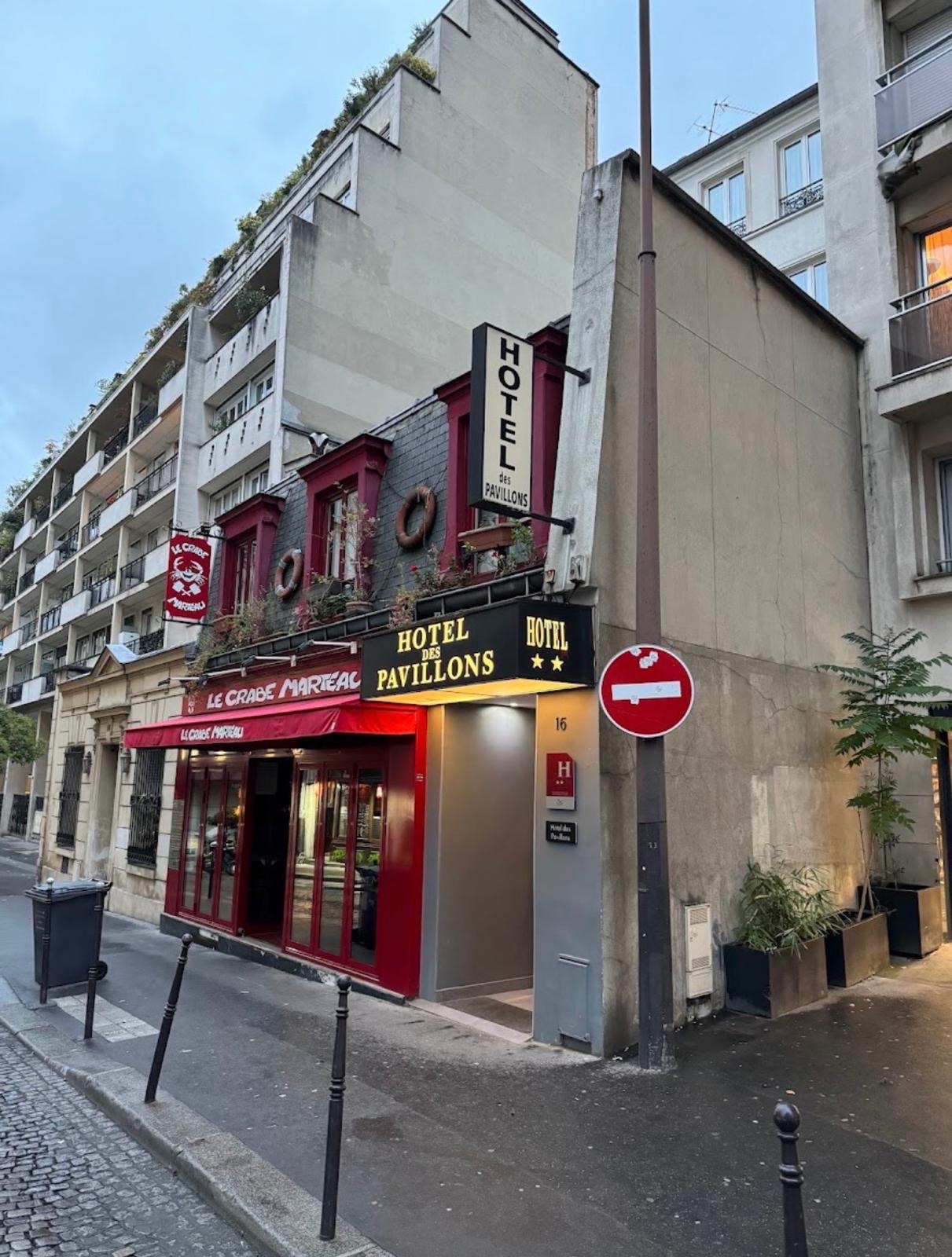 Façade de l'Hôtel des Pavillons dans le 17ᵉ arrondissement de Paris, enseigne deux étoiles et restaurant en rez-de-chaussée.
